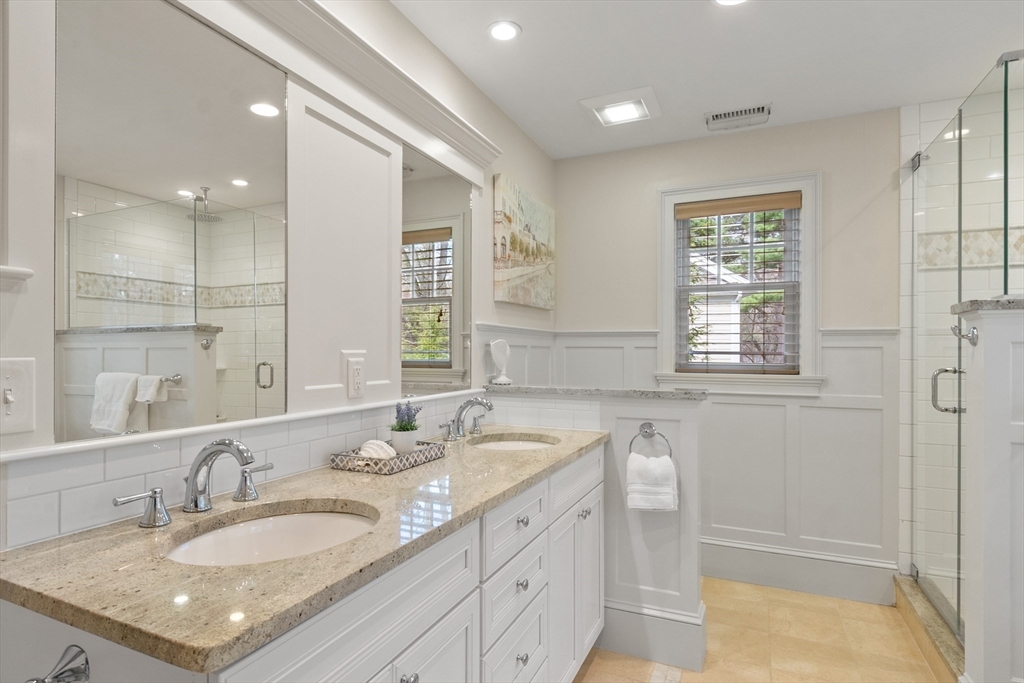 27 Maxwell Road Bedford, MA 01730 - Photo 17 of 41 a bathroom with a granite countertop sink a large mirror and a shower