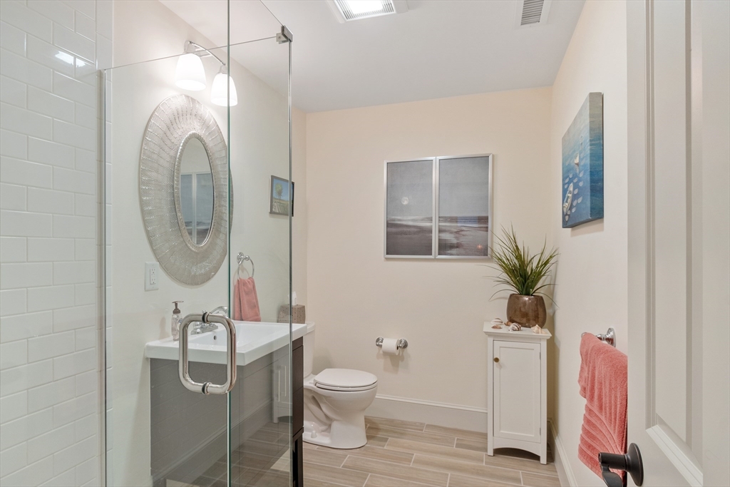 27 Maxwell Road Bedford, MA 01730 - Photo 22 of 41 a bathroom with a granite countertop sink a toilet and a mirror