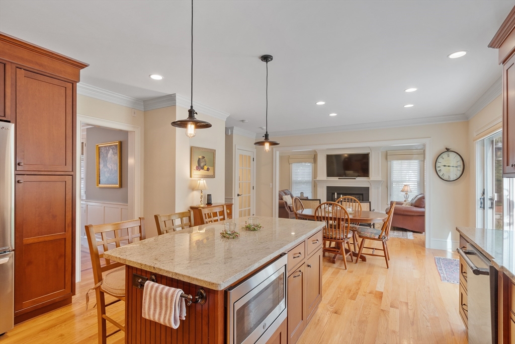 27 Maxwell Road Bedford, MA 01730 - Photo 5 of 41 a kitchen with stainless steel appliances granite countertop a kitchen island a table and chairs