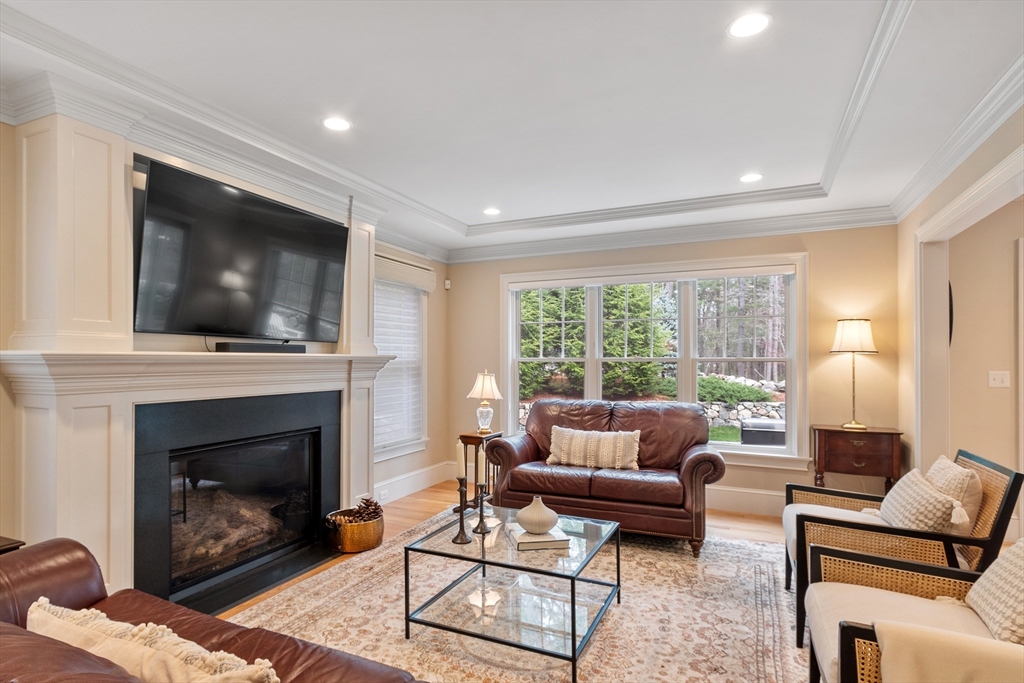 27 Maxwell Road Bedford, MA 01730 - Photo 8 of 41 a living room with furniture a flat screen tv and a fireplace