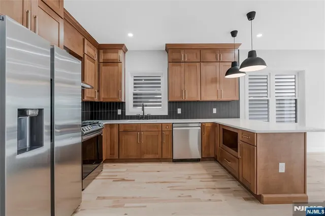 a kitchen with stainless steel appliances granite countertop a stove a sink and a refrigerator