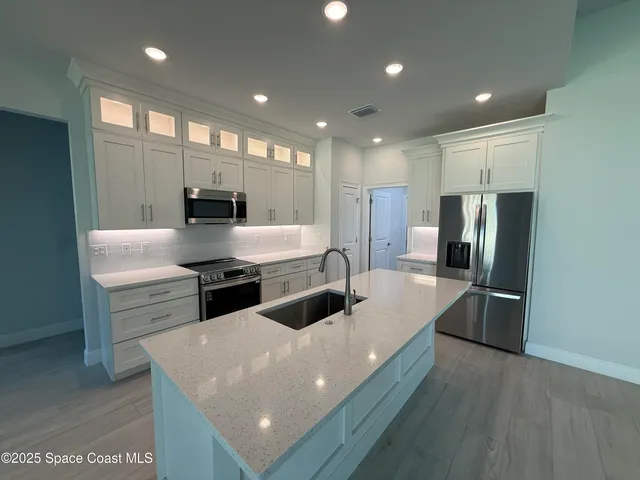 a large kitchen with stainless steel appliances a large counter top