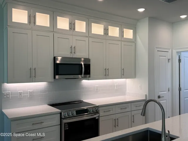 a kitchen with granite countertop a stove and a microwave