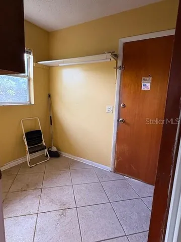 a view of an empty room with wooden floor and a cabinet