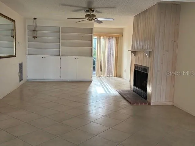 an empty room with fireplace and windows