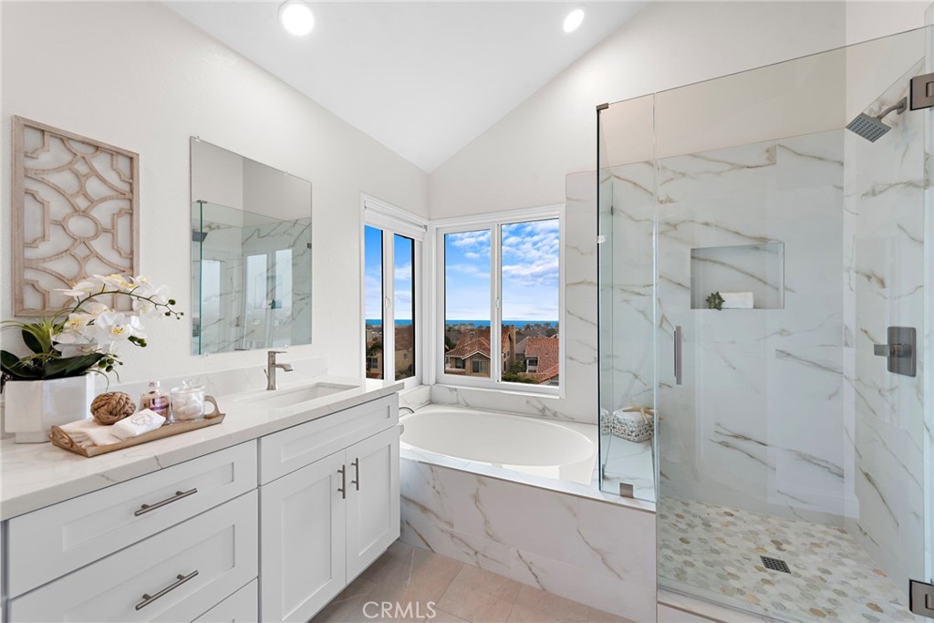 27 Regatta Way Dana Point, CA 92629 - Photo 13 of 24 a spacious bathroom with a granite countertop sink a mirror a shower and a bathtub