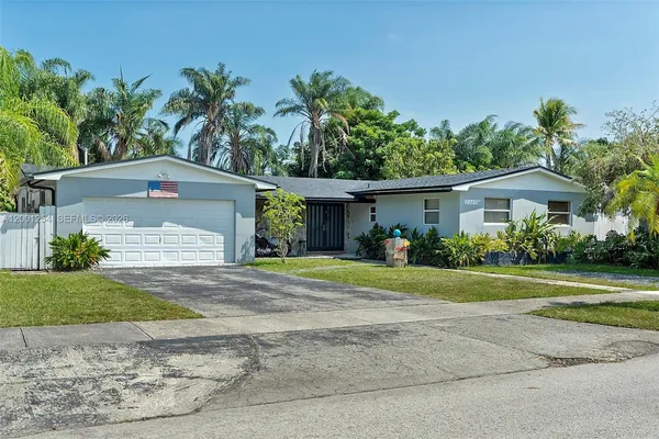 a front view of a house with a yard and a garage