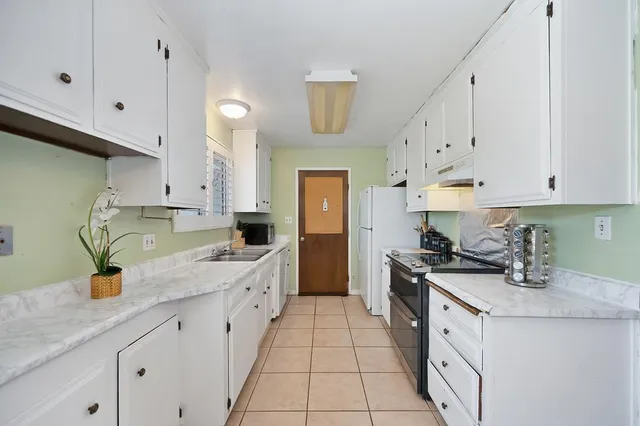 a kitchen with a sink a stove and cabinets