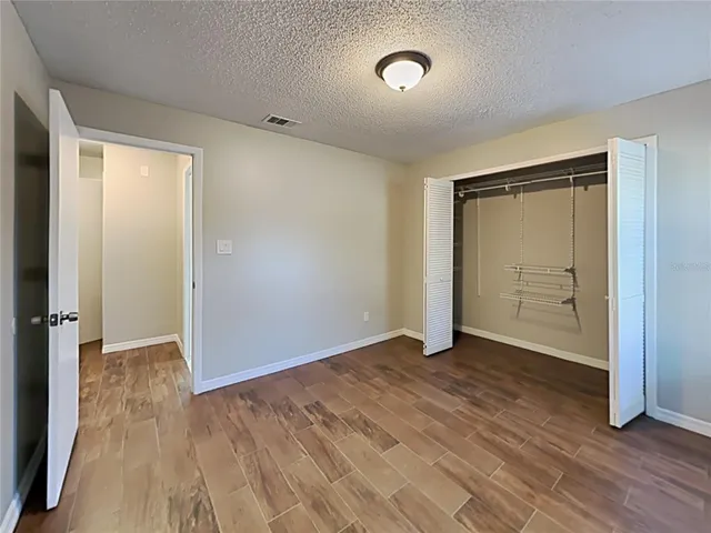 an empty room with wooden floor and closet