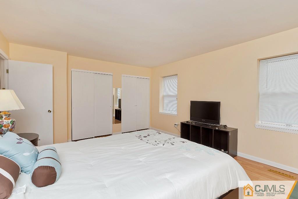 7704 Hana Road Edison, NJ 08817 - Photo 14 of 25 a bedroom with a bed and a flat screen tv