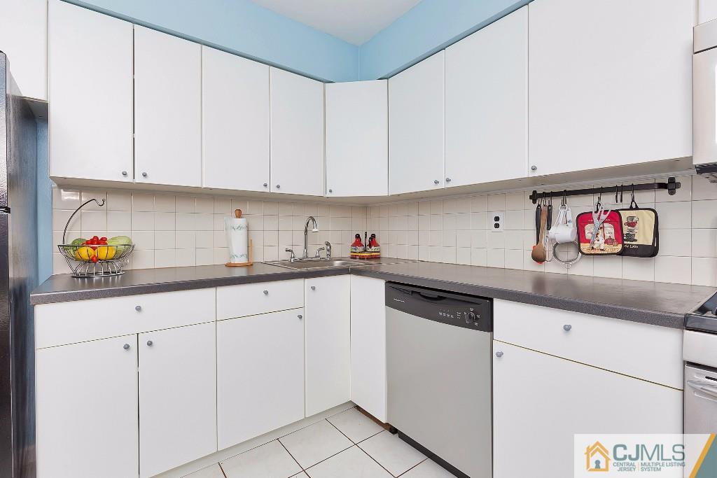 7704 Hana Road Edison, NJ 08817 - Photo 3 of 25 a kitchen with white cabinets and white appliances