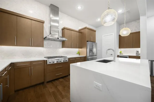 a kitchen that has a sink stainless steel appliances and cabinets