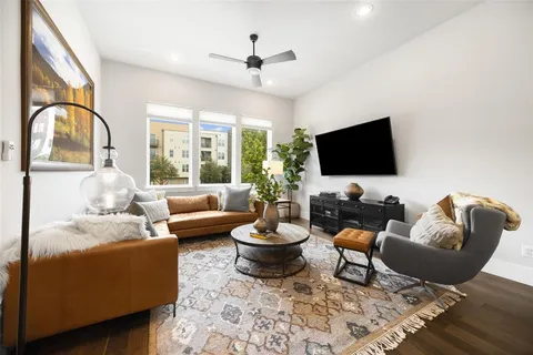 a living room with furniture a flat screen tv and a large window