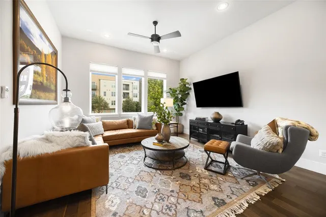 a living room with furniture a flat screen tv and a large window