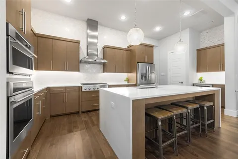 a kitchen with kitchen island granite countertop wooden cabinets and stainless steel appliances