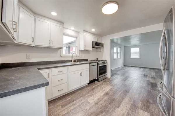 a kitchen with stainless steel appliances granite countertop a sink a stove and a refrigerator
