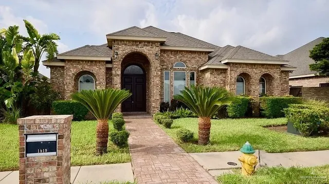 a front view of a house with a garden
