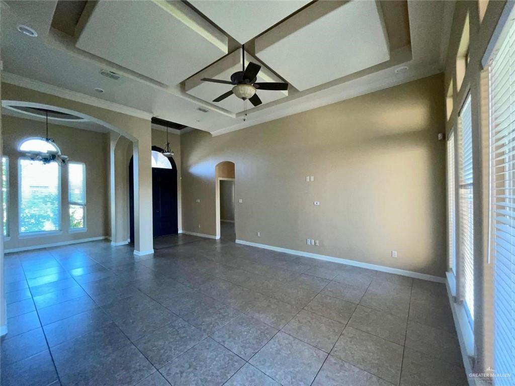 1919 West Ventura Drive Pharr, TX 78577 - Photo 16 of 20 Tiled empty room with arched walkways, coffered ceiling, ceiling fan, and beam ceiling
