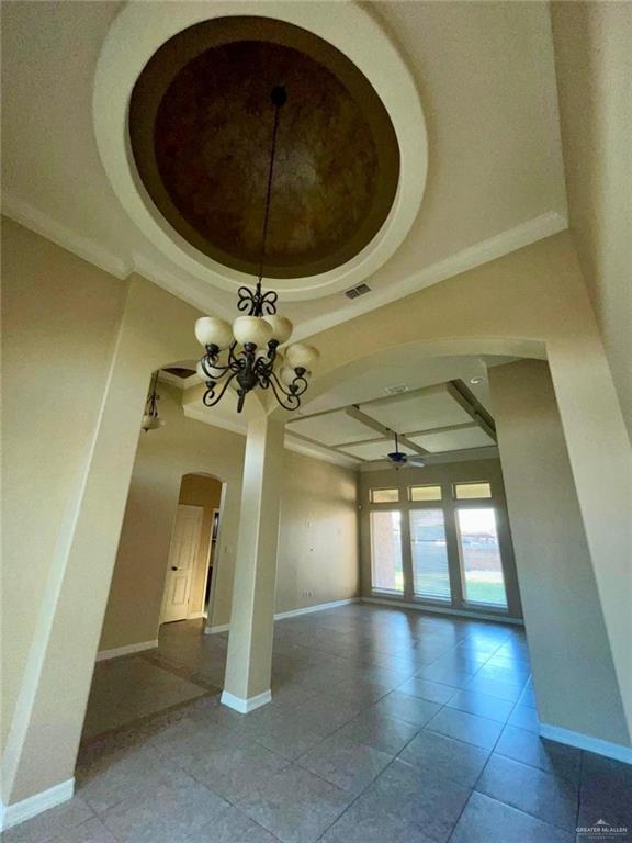 1919 West Ventura Drive Pharr, TX 78577 - Photo 3 of 20 Unfurnished room featuring coffered ceiling, arched walkways, beamed ceiling, ceiling fan, and tile patterned flooring