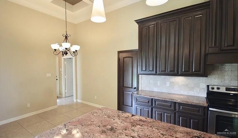 1919 West Ventura Drive Pharr, TX 78577 - Photo 4 of 20 Kitchen with electric range, dark brown cabinets, light stone countertops, pendant lighting, and light tile patterned flooring