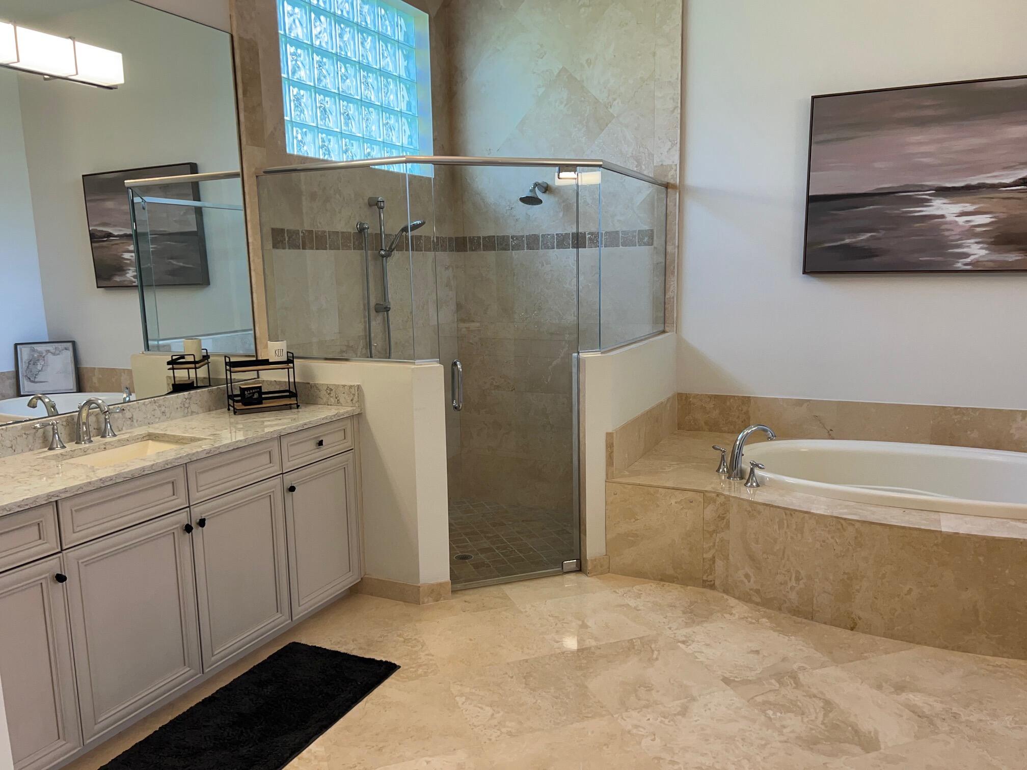 182 Rosalia Court Jupiter, FL 33478 - Photo 14 of 29 a bathroom with a tub a sink and a mirror