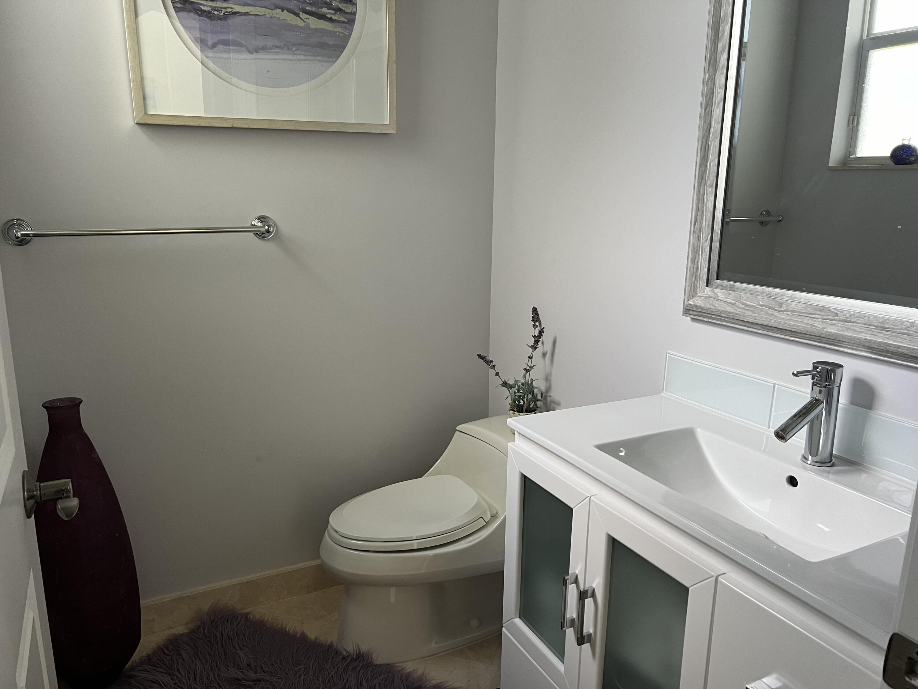 182 Rosalia Court Jupiter, FL 33478 - Photo 16 of 29 a bathroom with a toilet sink and mirror