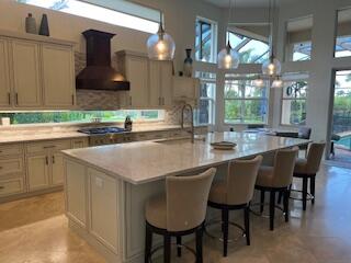 182 Rosalia Court Jupiter, FL 33478 - Photo 3 of 29 a kitchen with a sink a table and chairs