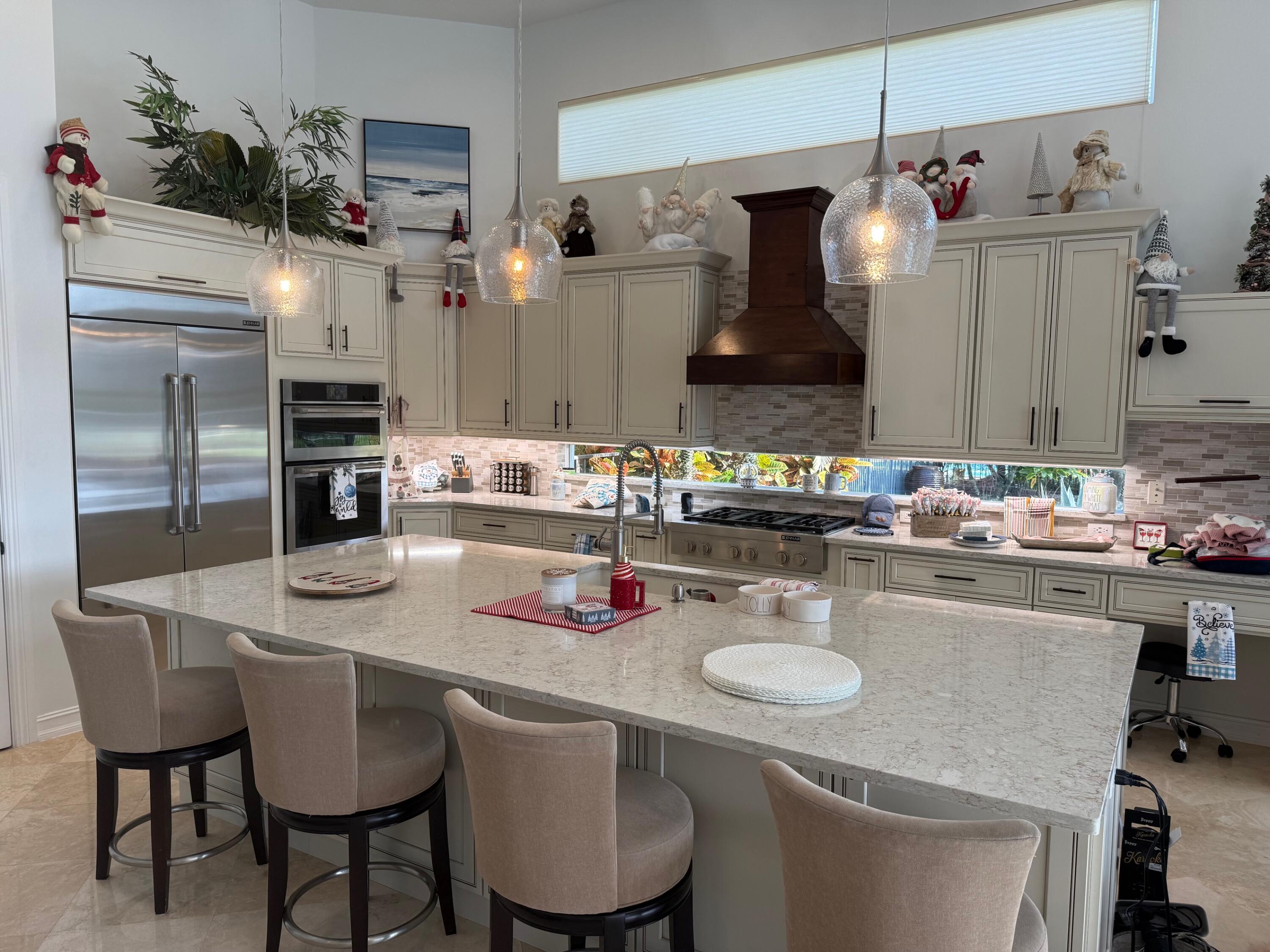 182 Rosalia Court Jupiter, FL 33478 - Photo 4 of 32 a kitchen with a table chairs and microwave