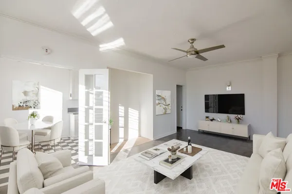 a living room with furniture a flat screen tv and a large window