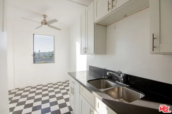 a kitchen with a sink a refrigerator and cabinets