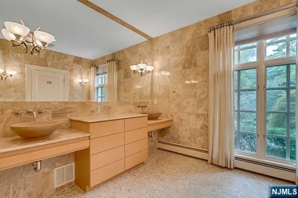 a spacious bedroom with a bed a dresser and large windows