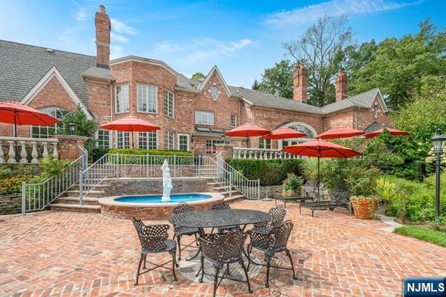 1055 High Mountain Road Franklin Lakes, NJ 07417 - Photo 24 of 42 a patio with a table and chairs under an umbrella