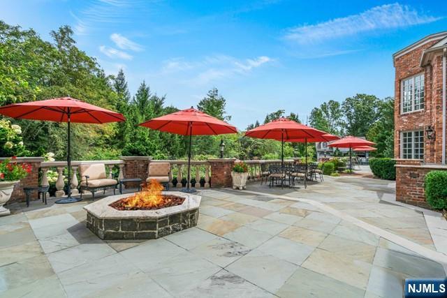1055 High Mountain Road Franklin Lakes, NJ 07417 - Photo 6 of 42 a view of a patio with a table and chairs under an umbrella