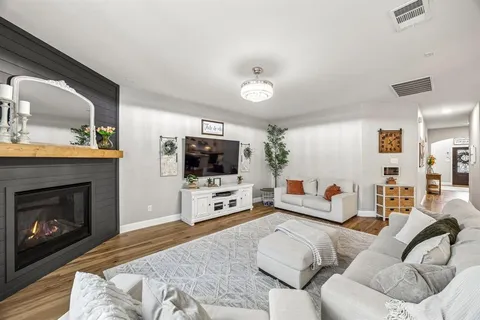 a living room with furniture a flat screen tv and a fireplace