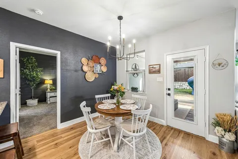 a dining room with furniture a chandelier and wooden floor