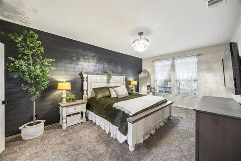 a bedroom with a bed and a potted plant