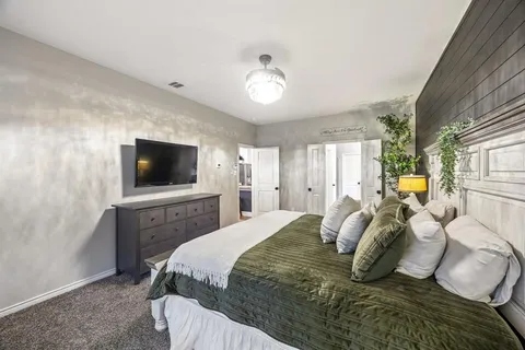 a bedroom with a large bed and a flat screen tv