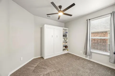 a view of a livingroom with a ceiling fan and window
