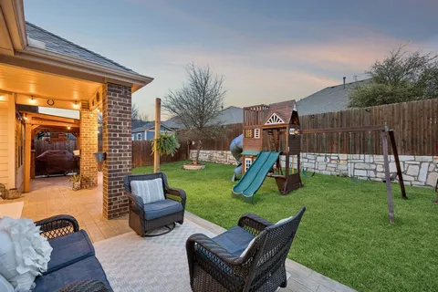 a view of a backyard with furniture and a slide