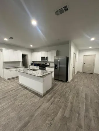 a large kitchen with cabinets and stainless steel appliances