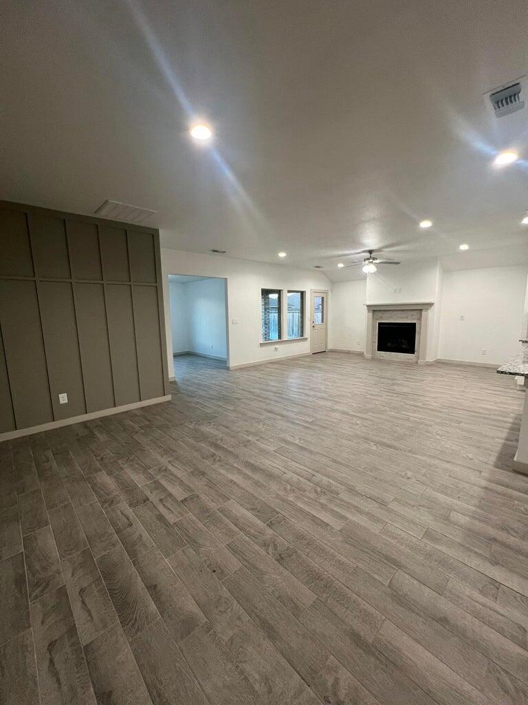 10518 Aberdeen Avenue Lubbock, TX 79424 - Photo 6 of 20 an empty room with wooden floor and fireplace