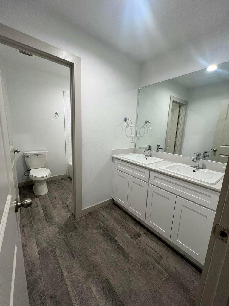 10518 Aberdeen Avenue Lubbock, TX 79424 - Photo 9 of 20 a spacious bathroom with a double vanity sink a mirror and a toilet