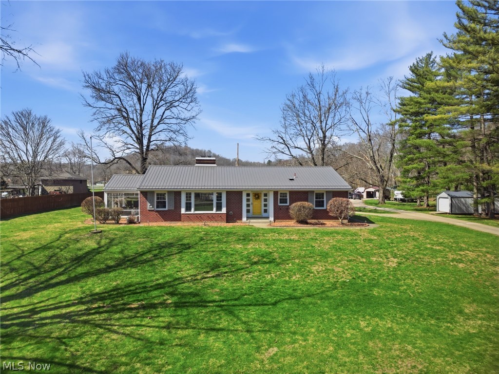 6655 Ceramic Road Crooksville, OH 43731 - Photo 1 of 34 Ranch-style home featuring brick siding, an outdoor structure, and a metal roof