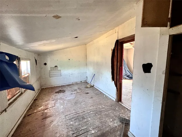 a view of a hallway to a bedroom with windows