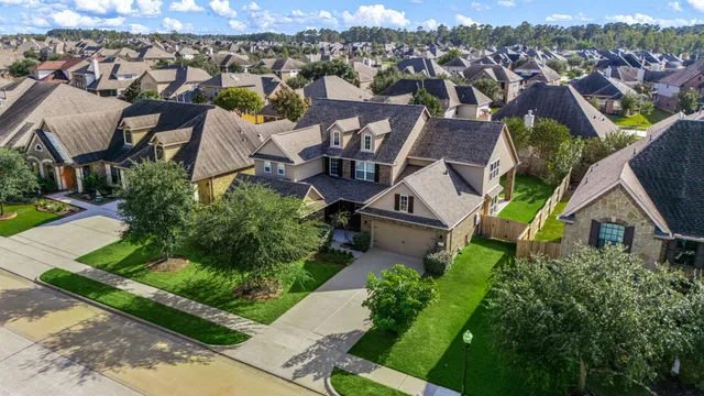 an aerial view of a house with a yard and lake view