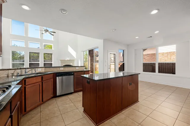 a large kitchen with stainless steel appliances granite countertop a large counter top and a stove