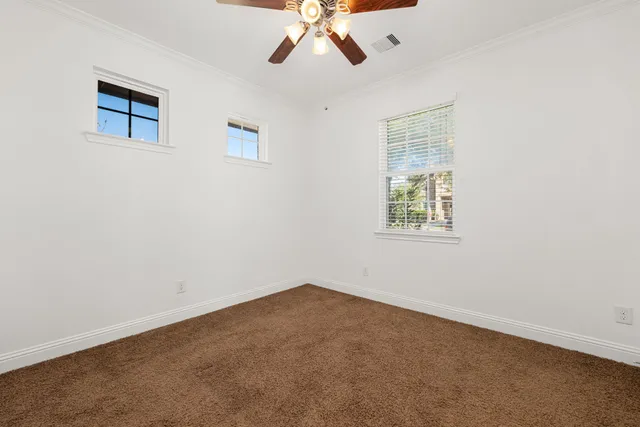 an empty room with a window and a ceiling fan