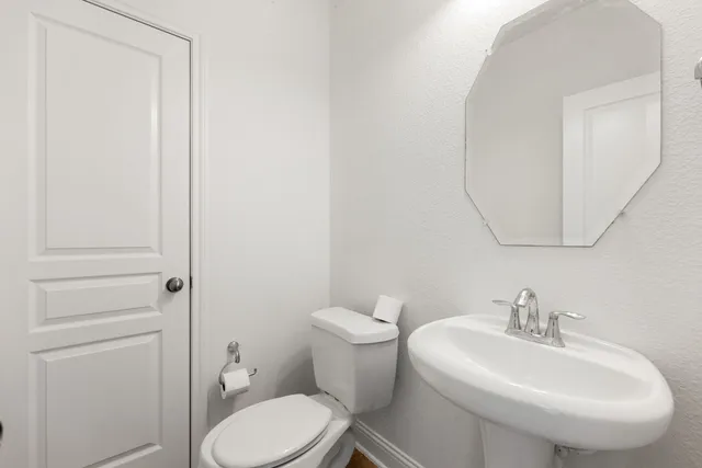 a bathroom with a sink a toilet and a mirror