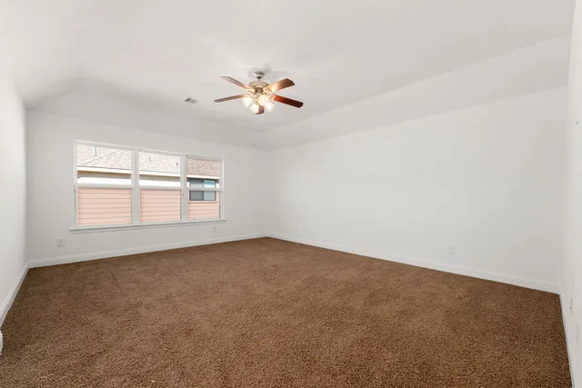 an empty room with a window and a ceiling fan
