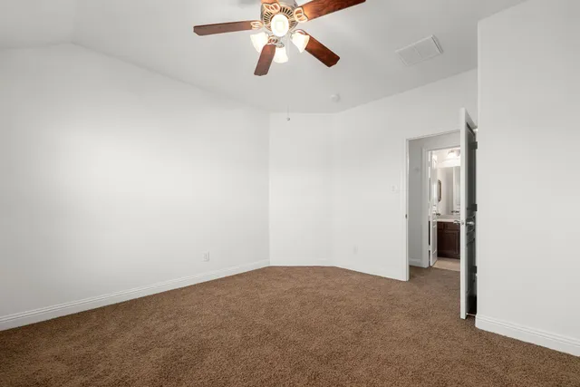an empty room with chandelier fan